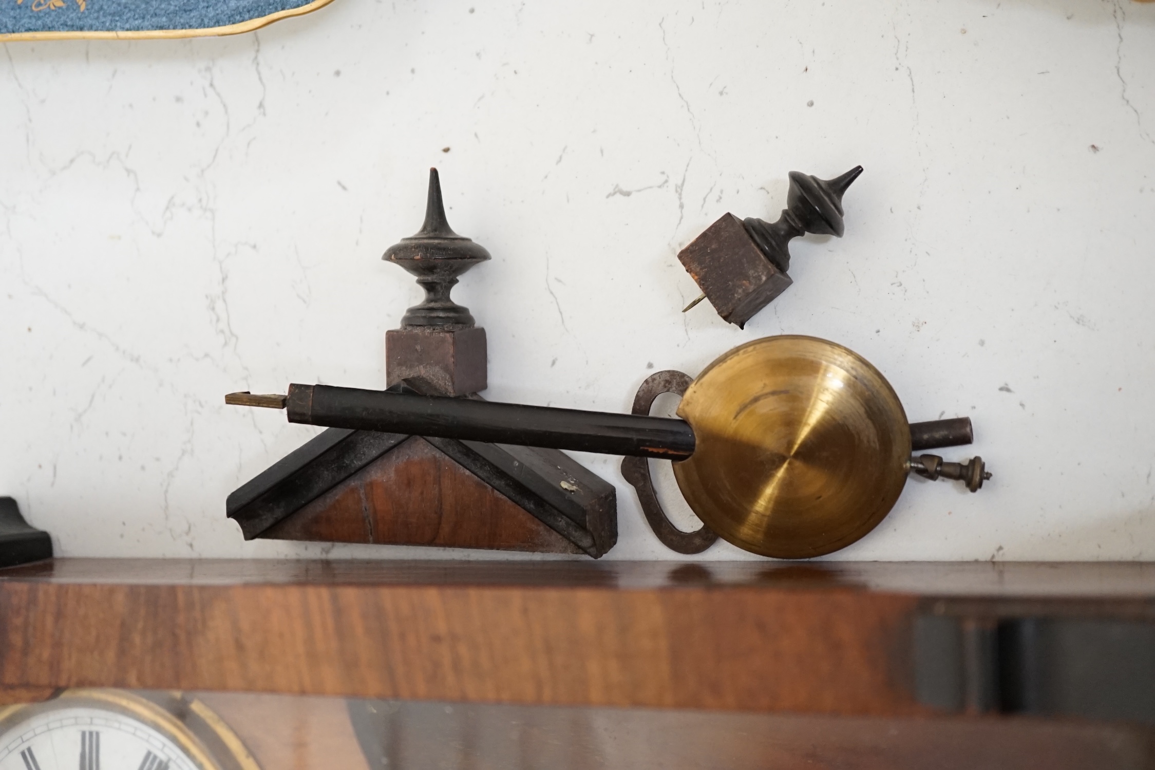 A small walnut cased wall clock with enamel dial with pendulum and key. Condition - poor